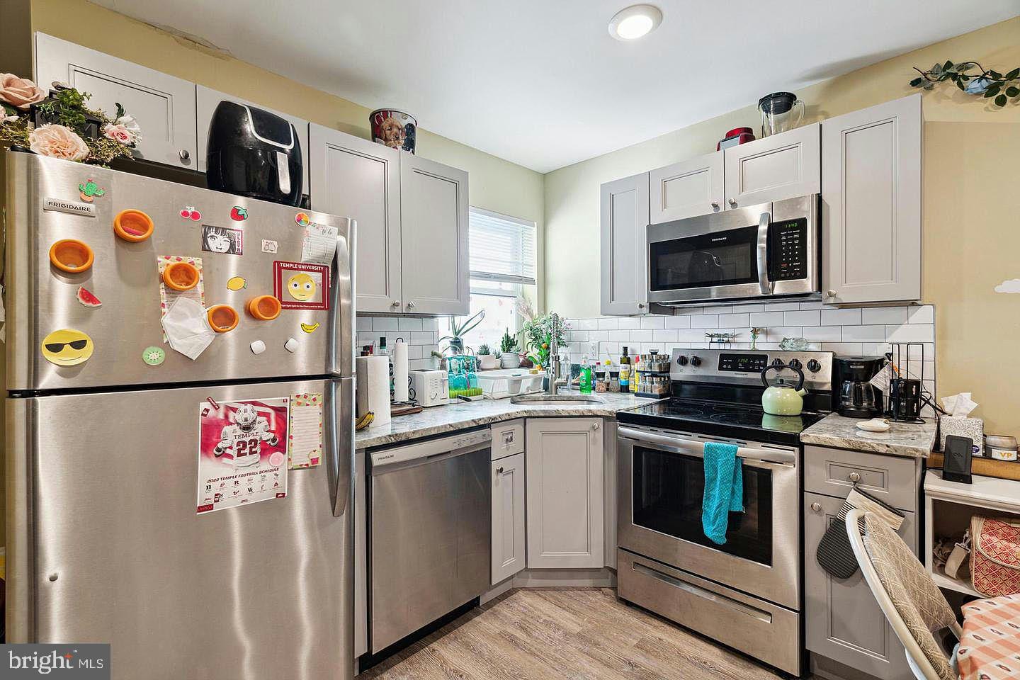 a kitchen with stainless steel appliances granite countertop a refrigerator sink stove and microwave