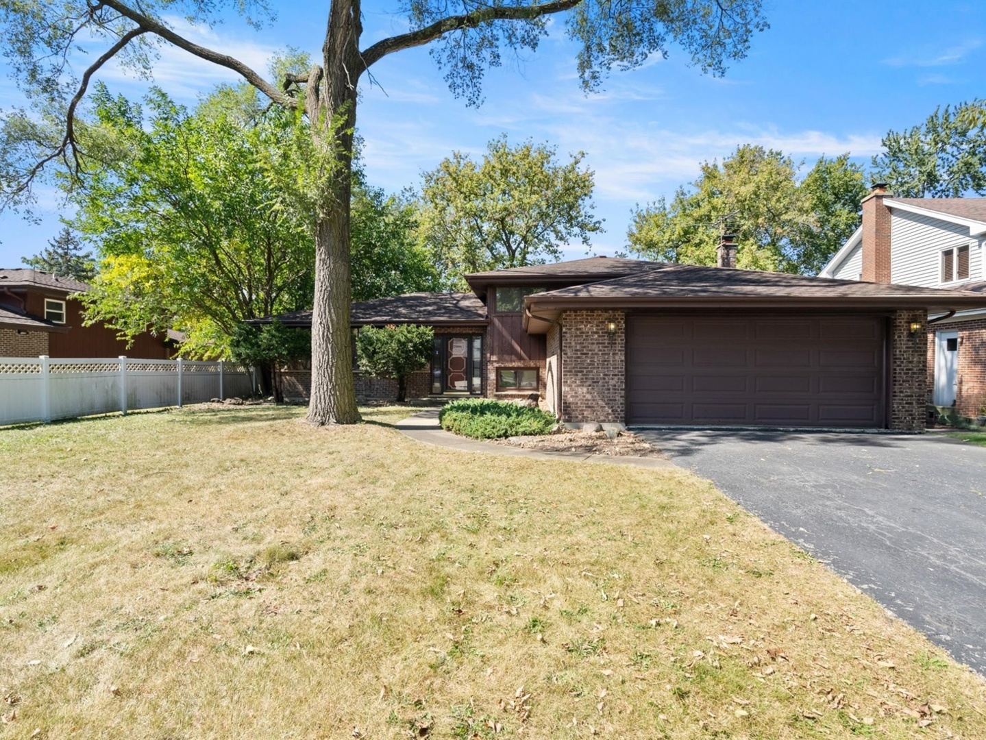 a front view of a house with a yard garage and tree