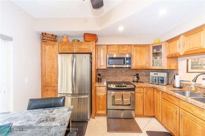 a kitchen with stainless steel appliances granite countertop a stove and a refrigerator