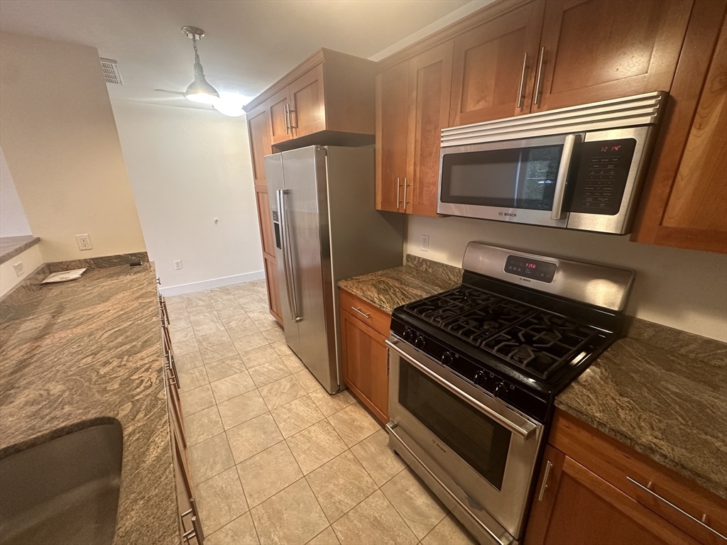 a kitchen with granite countertop a stove and a microwave