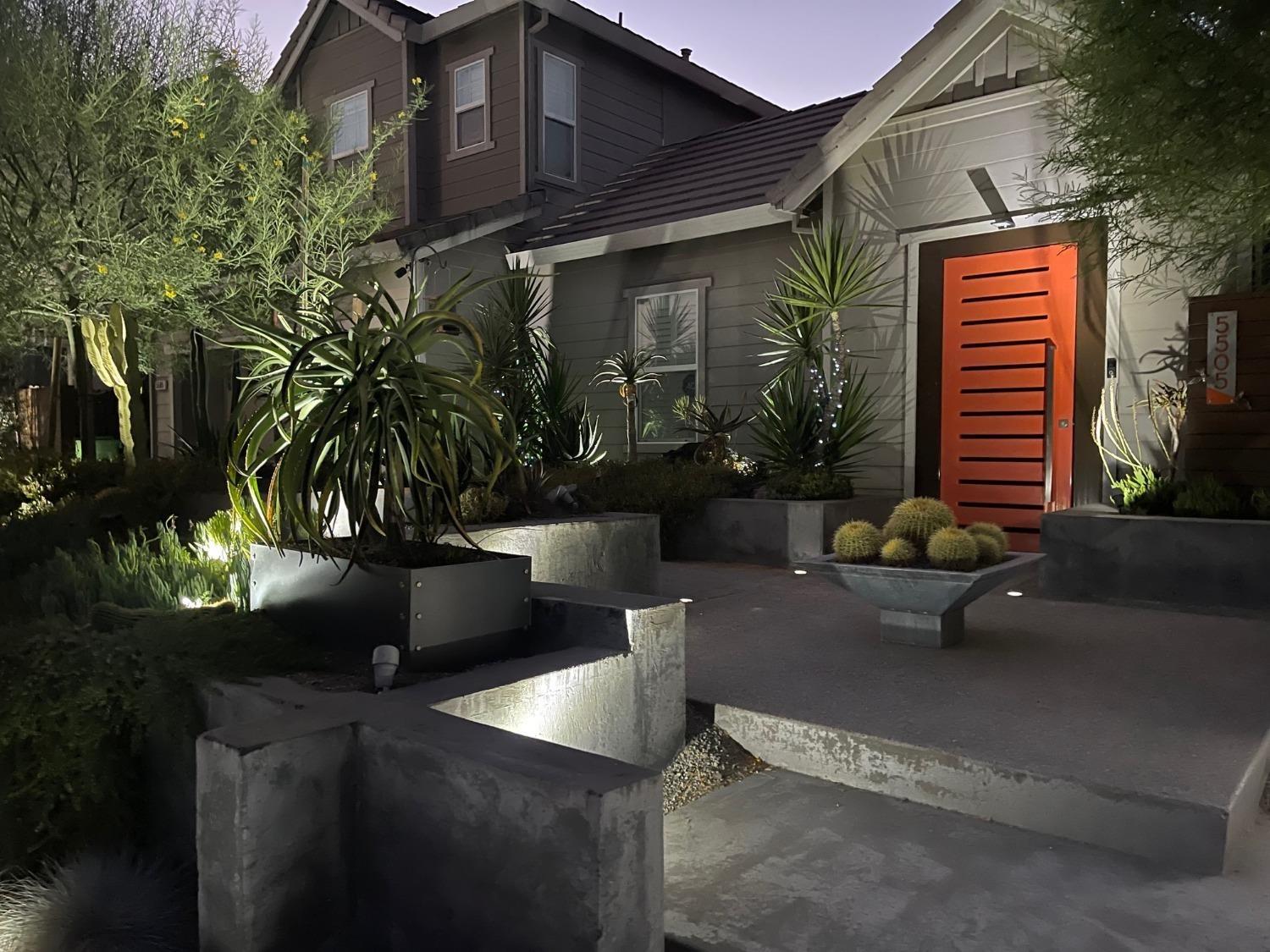 a view of a patio with table and chairs potted plants and palm tree