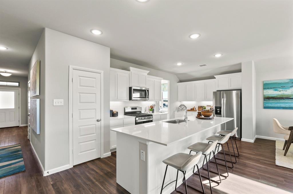 a kitchen with a sink a refrigerator and cabinets