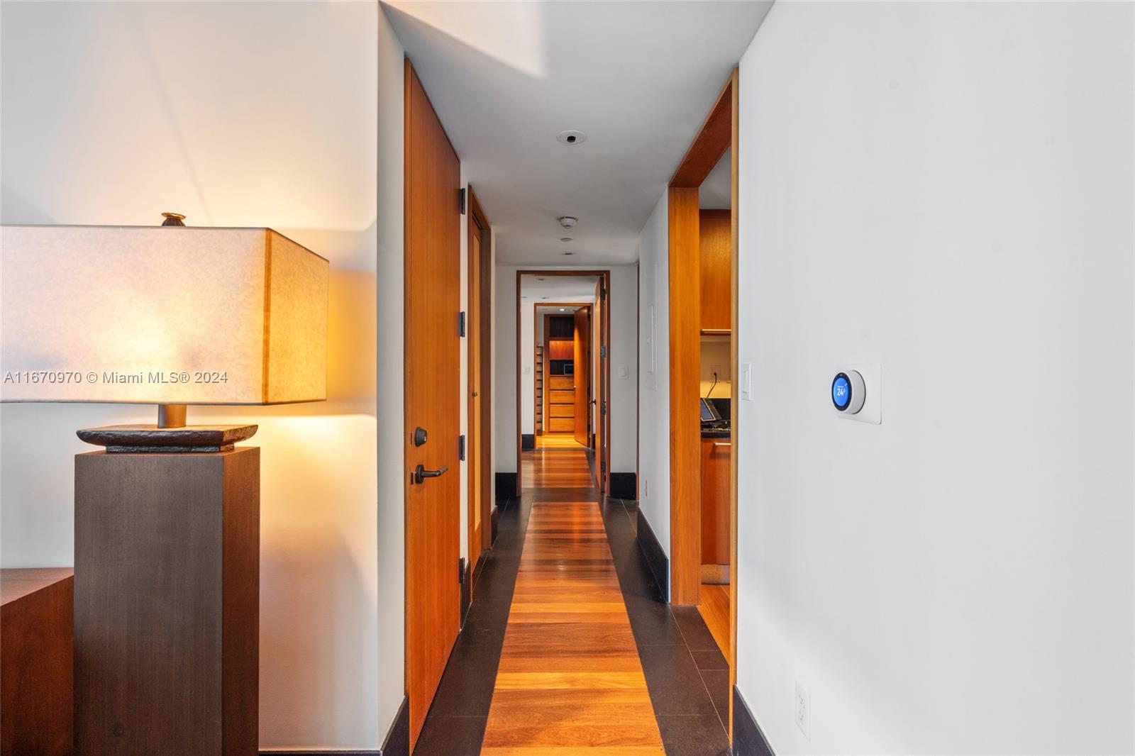 a view of a hallway with wooden floor and staircase