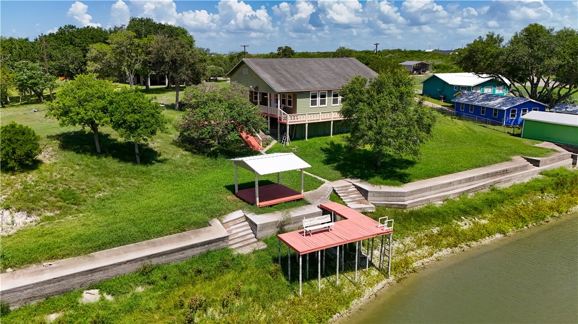 an aerial view of a house with a garden and lake view