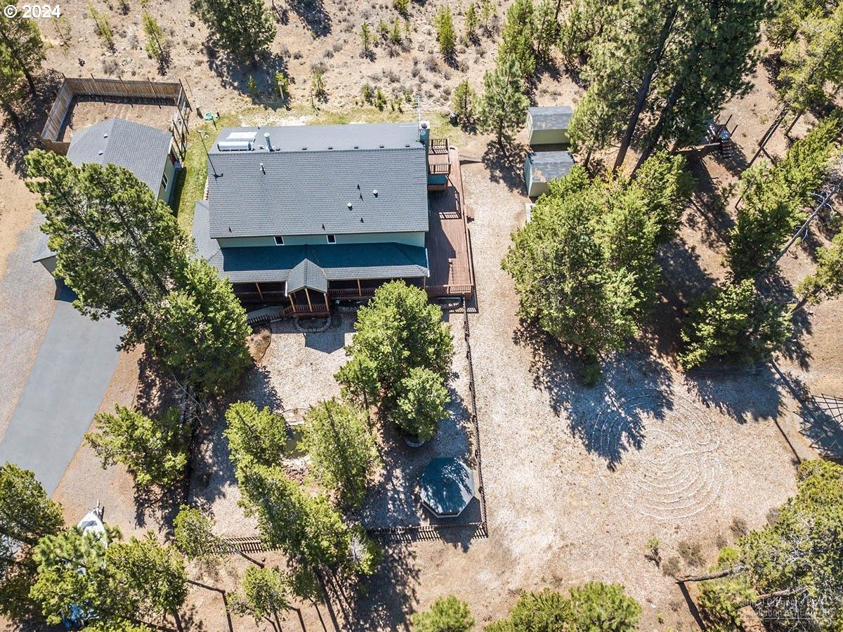 an aerial view of residential house with outdoor space and trees all around