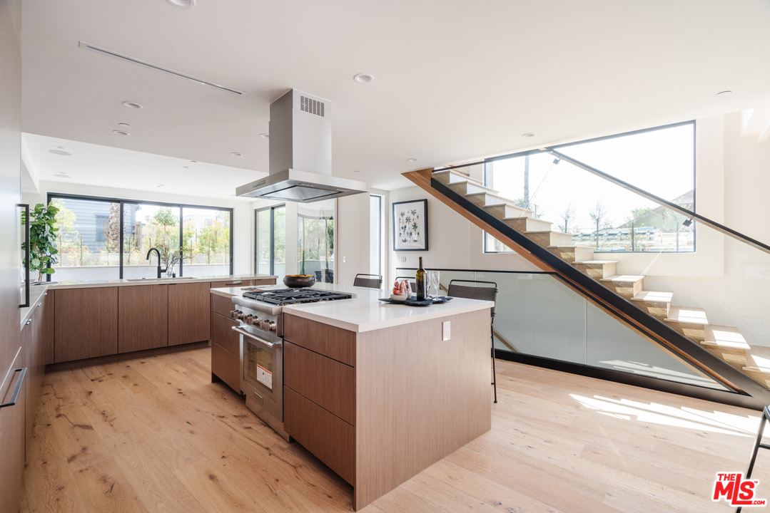 a kitchen with a stove a refrigerator and a large window