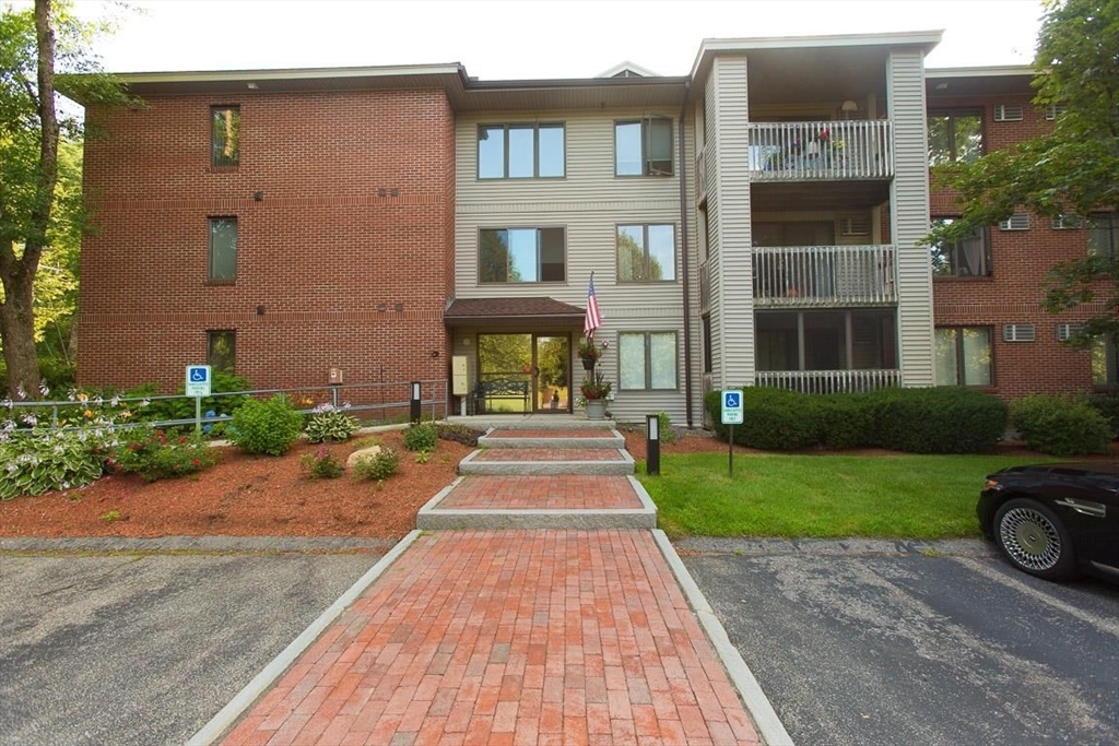 a front view of a house with a yard and potted plants