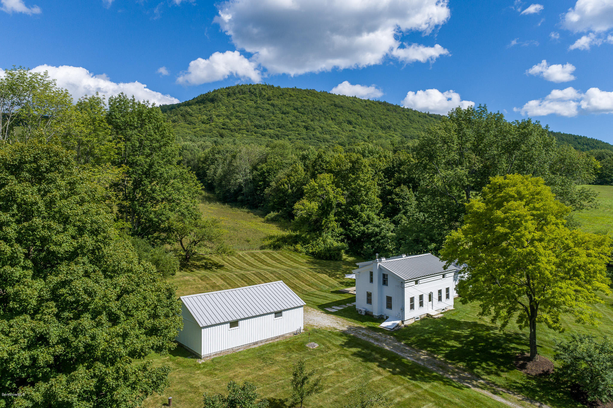 an aerial view of a house with yard and green space