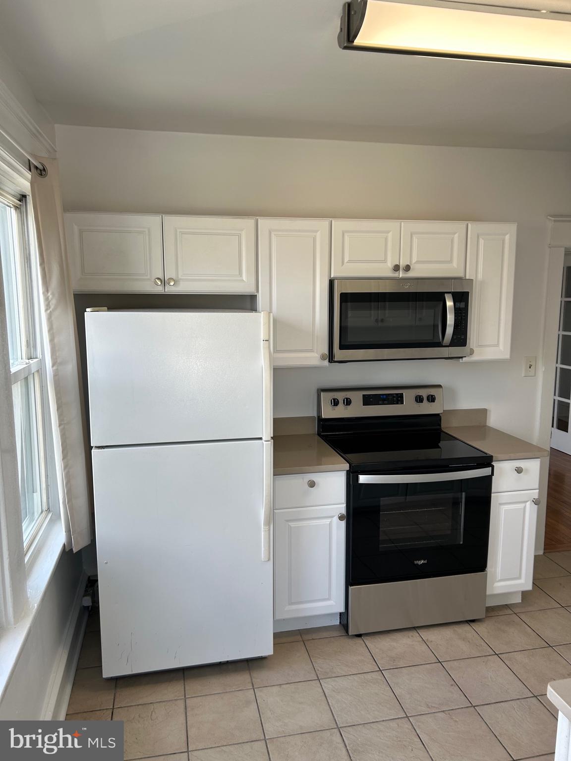 a white refrigerator freezer and a stove sitting inside of a kitchen