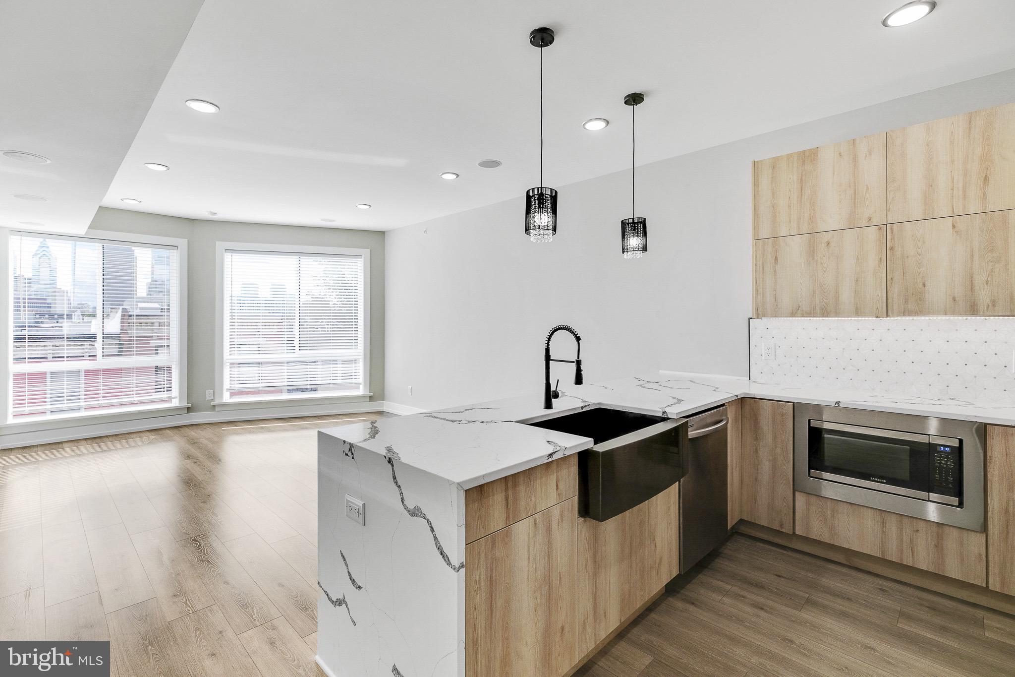 a kitchen that has a sink a stove and a wooden floor