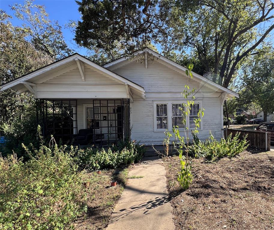 a front view of house with yard and trees around