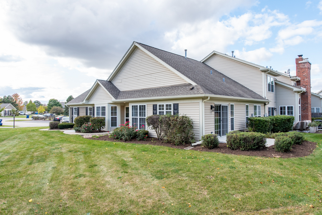 a front view of a house with a yard and potted plants