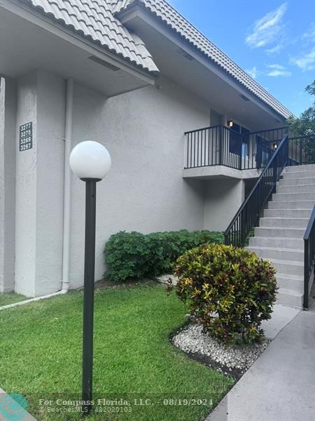 a view of a house with a small yard and a fountain