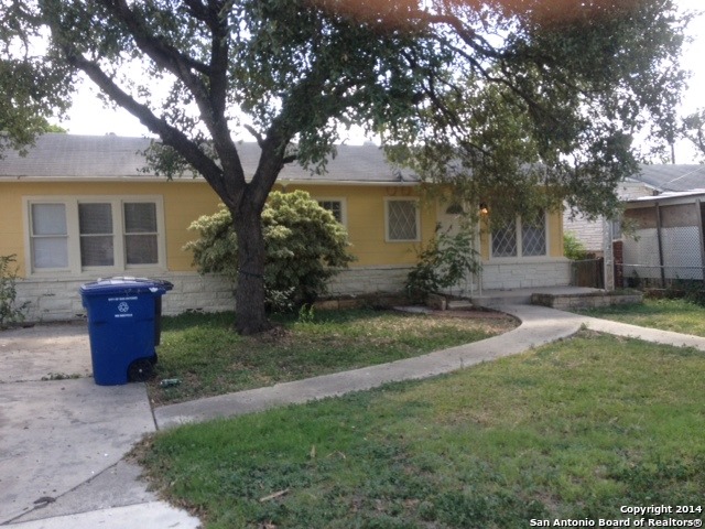 a view of a house with backyard and a tree