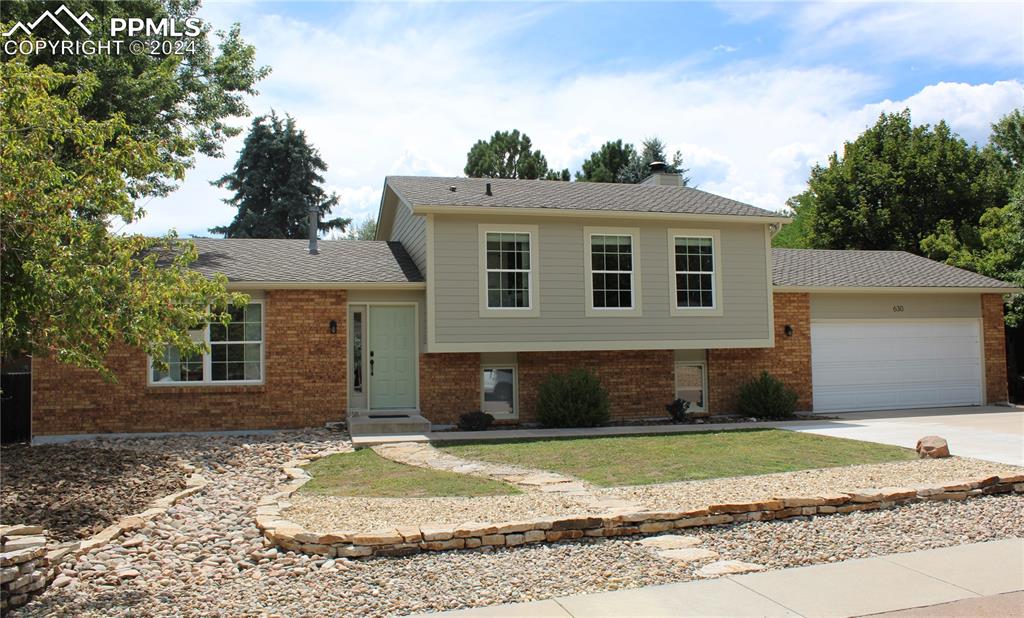 a front view of a house with a yard and garage