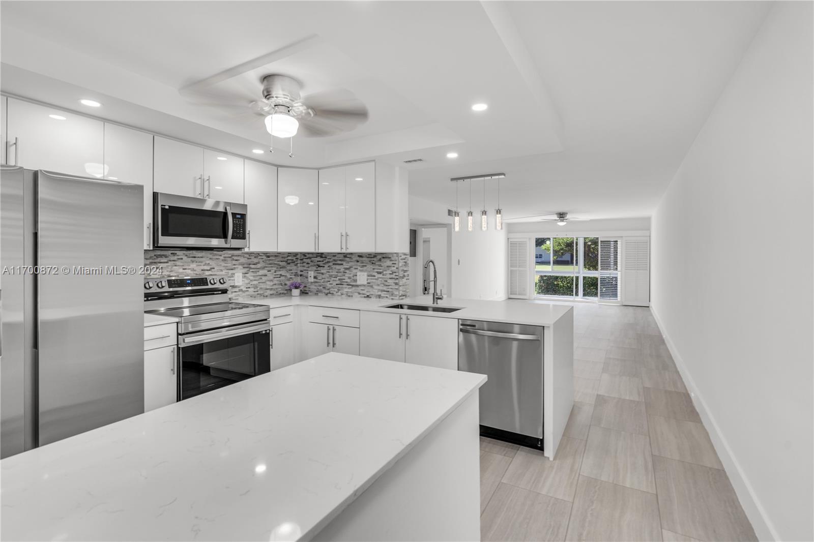 a kitchen with kitchen island a stove a sink and a refrigerator