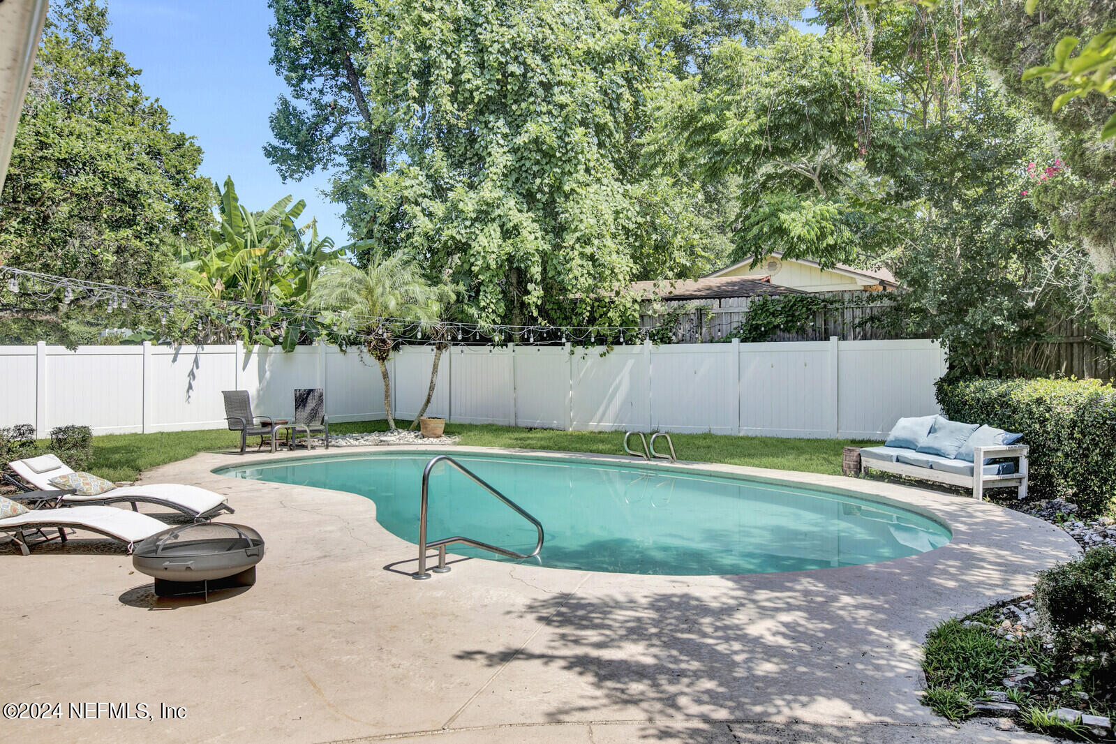 a view of a backyard with wooden fence and a slide