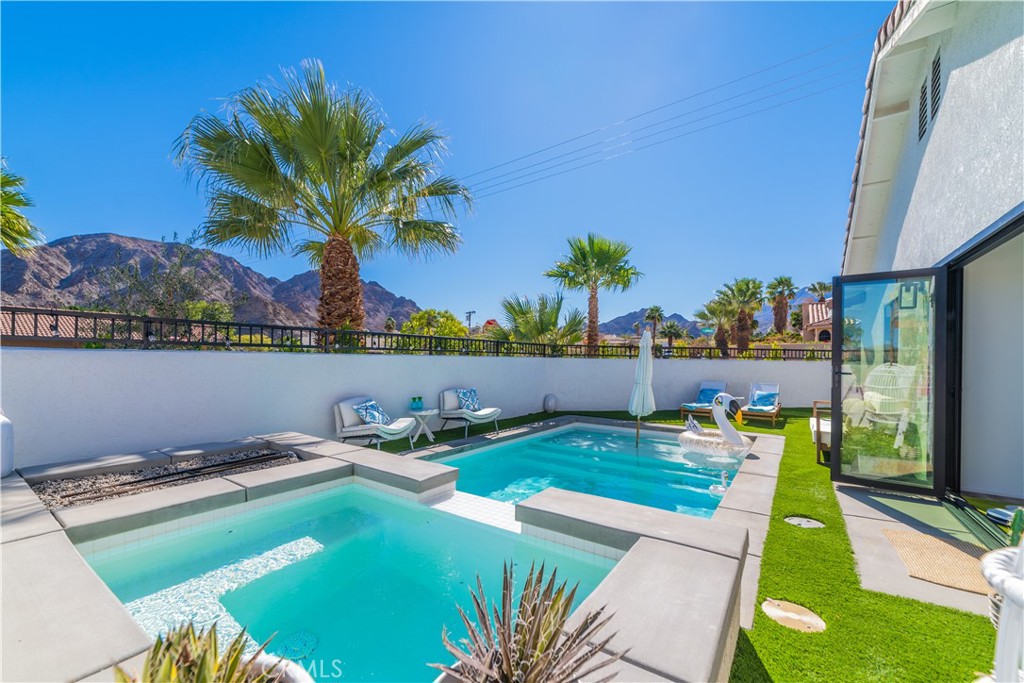 a view of a swimming pool with a yard and plants