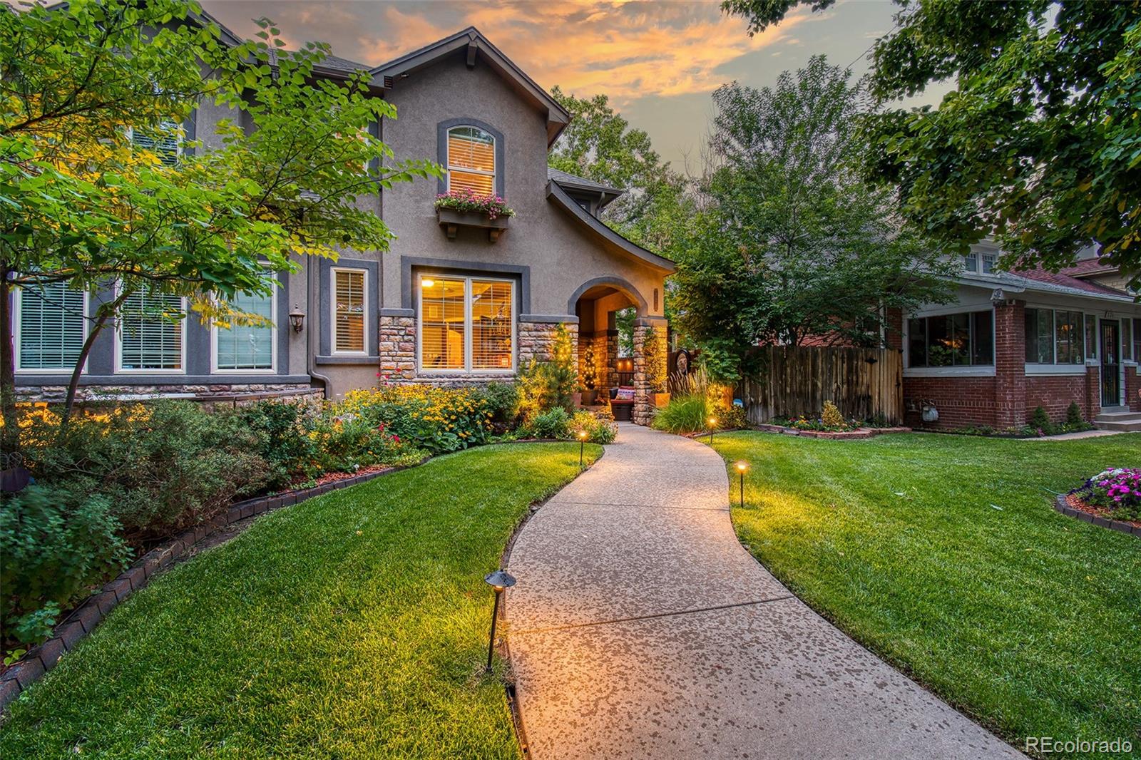 a front view of a house with a yard and garden