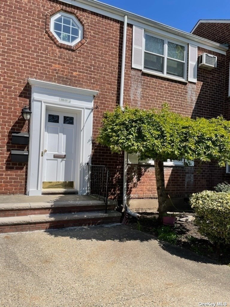 front view of a brick house with a yard