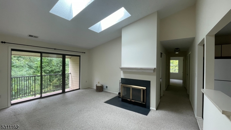 a view of an empty room with a fireplace and a window