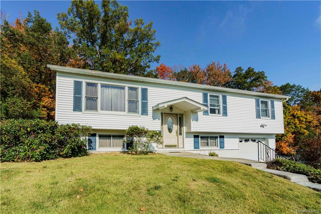 Bi-level home with a garage and a front yard