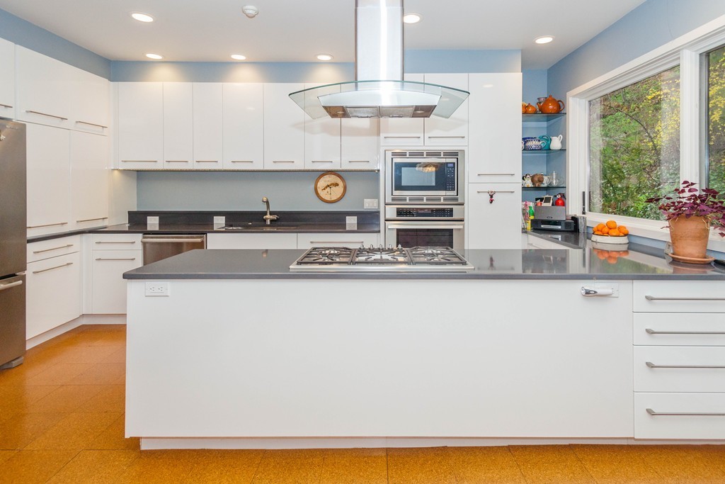 a kitchen with stainless steel appliances granite countertop a sink and a stove