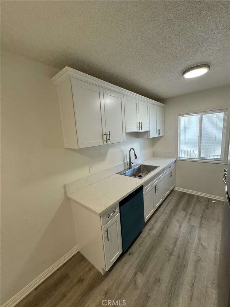 a kitchen with sink cabinets and wooden floor