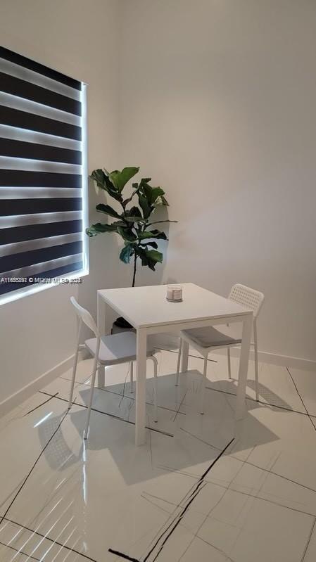 a view of a dining room with furniture and a potted plant