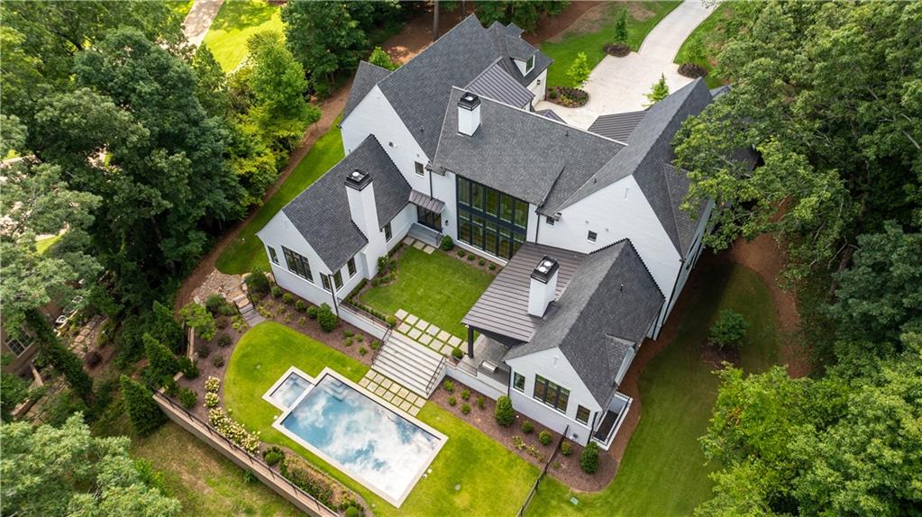 an aerial view of residential house with outdoor space and trees all around