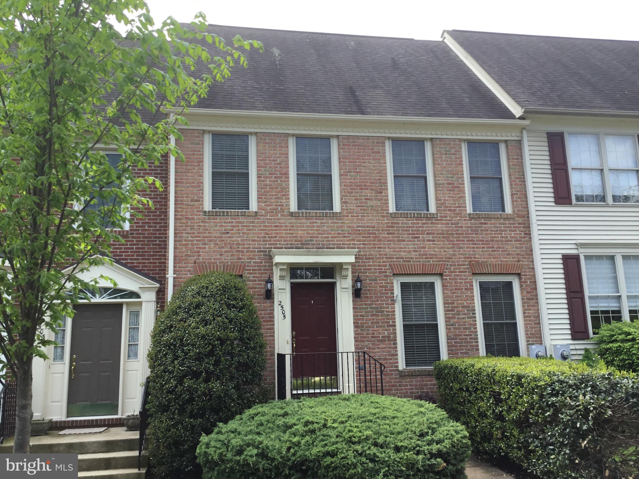 front view of a brick house with a yard