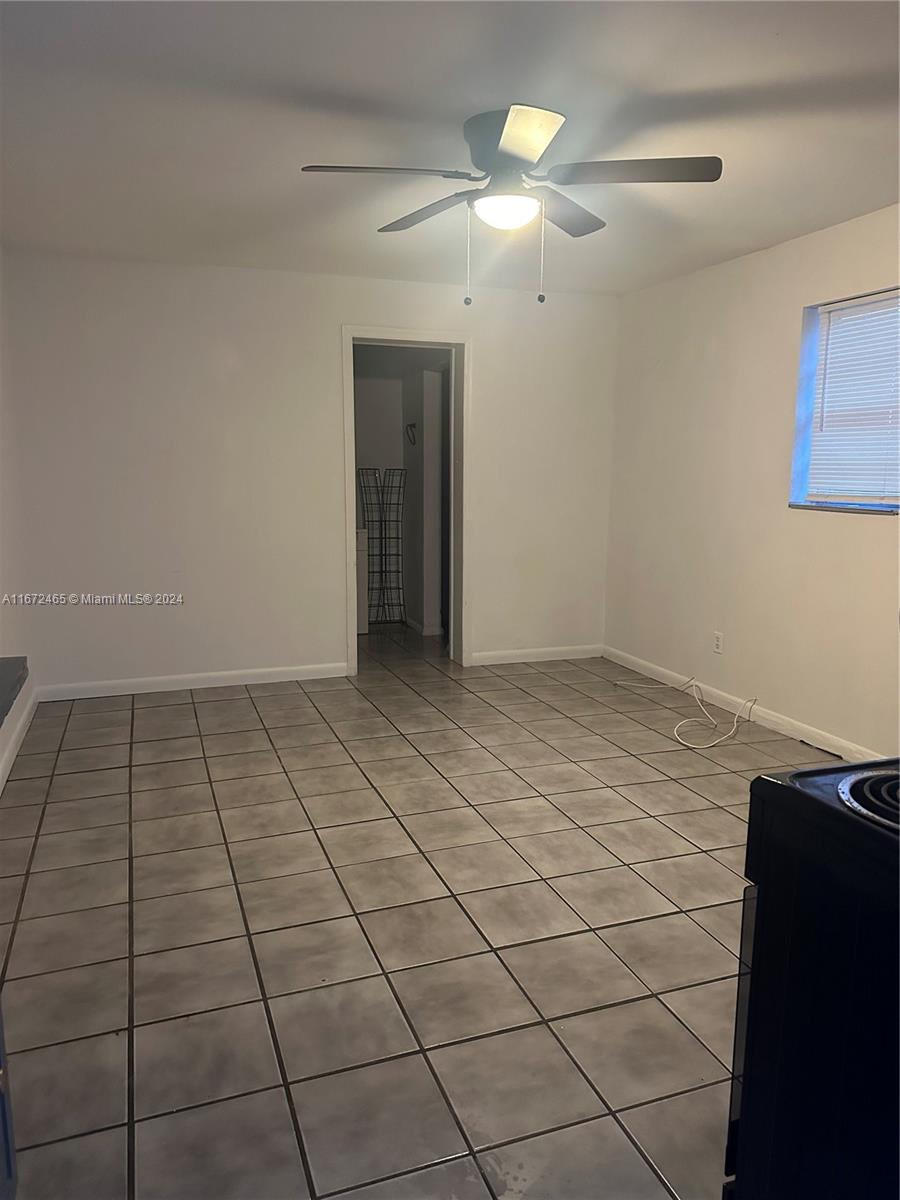 a view of an empty room and chandelier fan