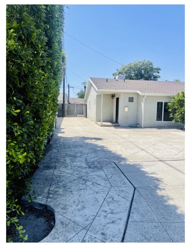 a front view of a house with a yard and potted plants