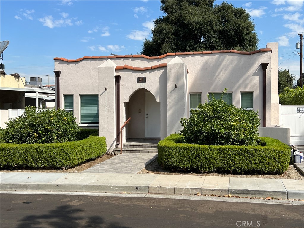 a front view of a house with garage and plants