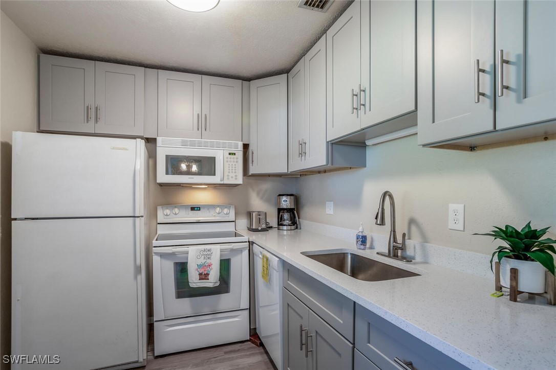 a kitchen with appliances a sink and cabinets