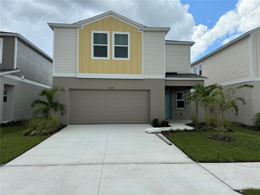 a front view of a house with a yard and garage