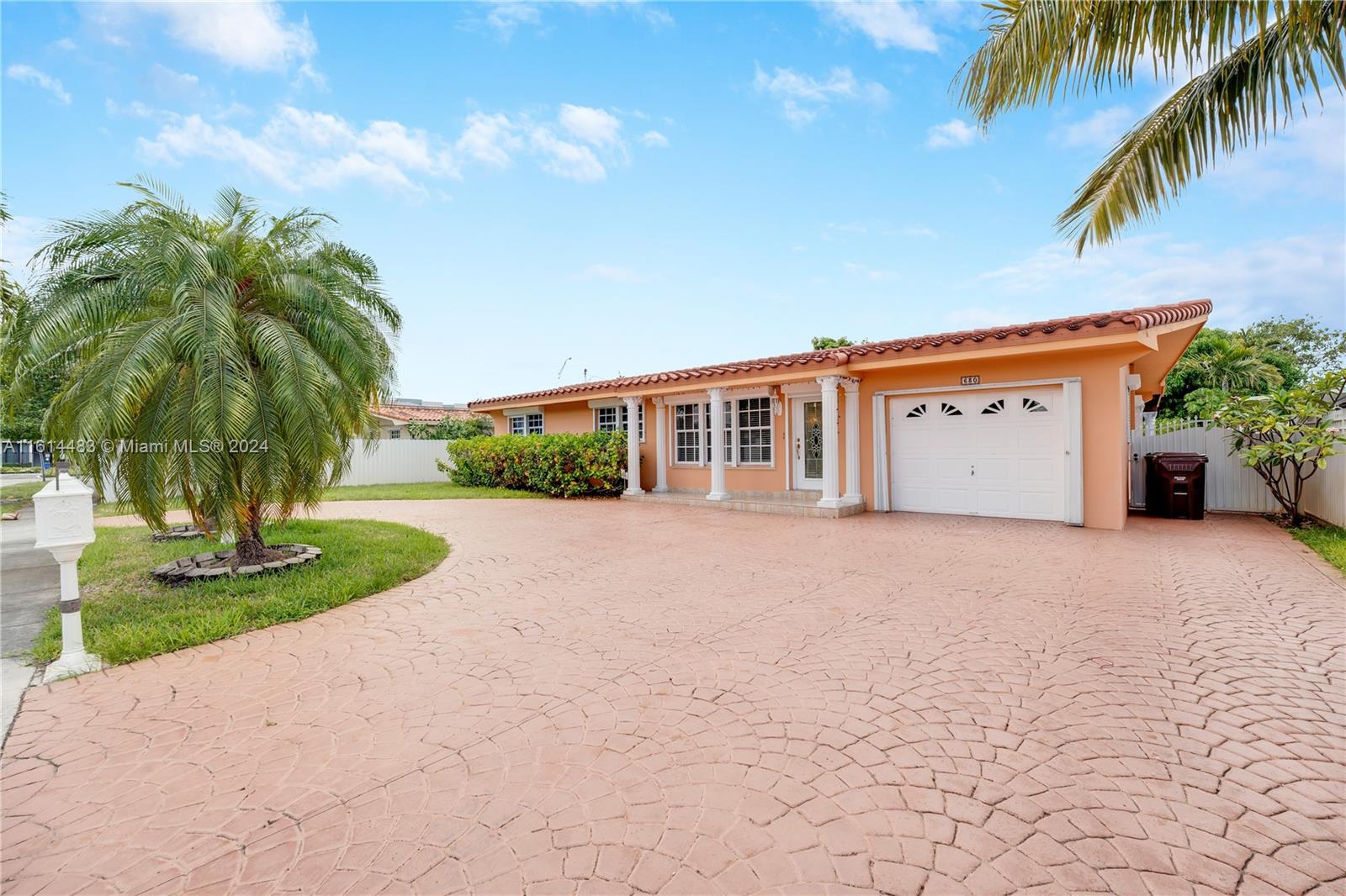 a palm tree sitting in front of a house with a yard