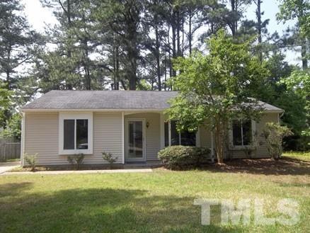 a front view of house with yard and trees around