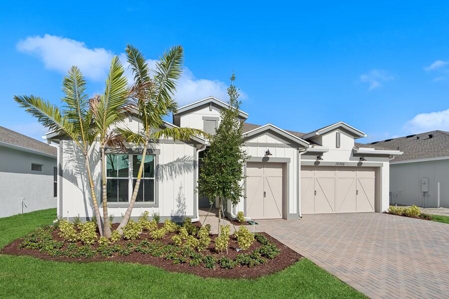 a front view of a house with a garden and yard