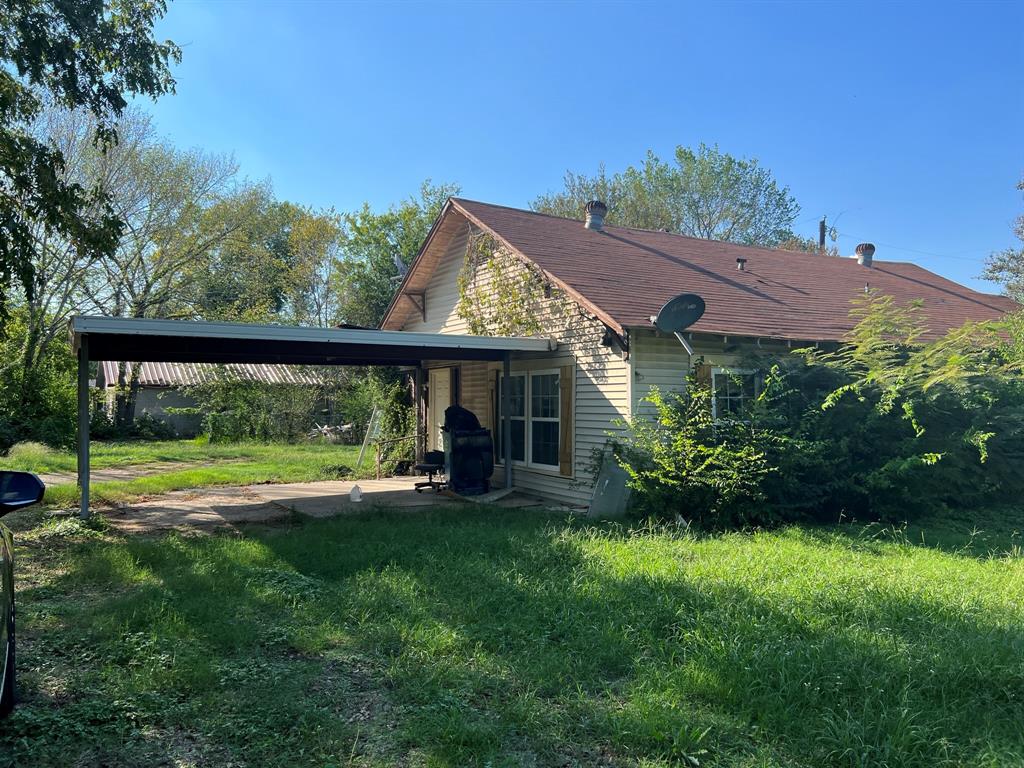 a view of a house with backyard and sitting area