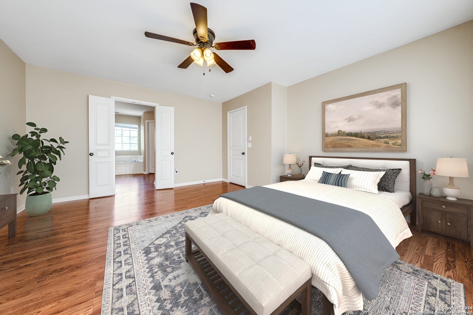 a spacious bedroom with a bed and a potted plant