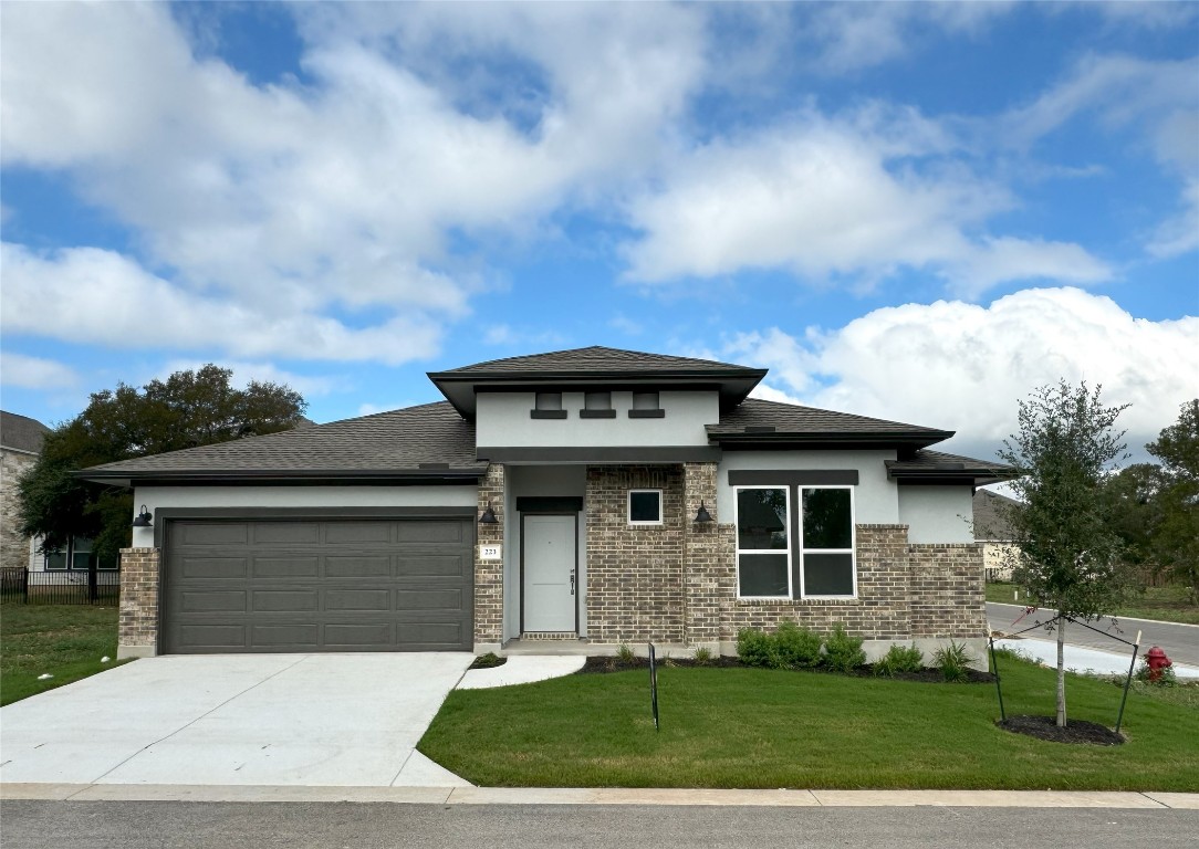 a front view of a house with a yard and garage