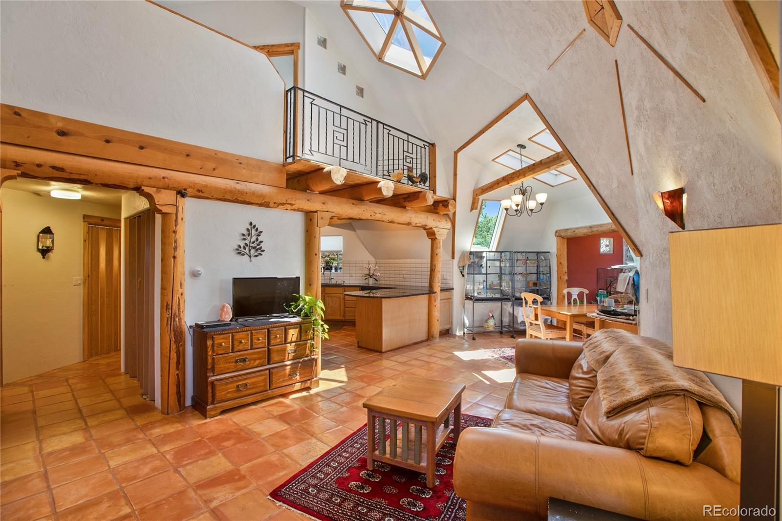 a living room with furniture a flat screen tv and kitchen view