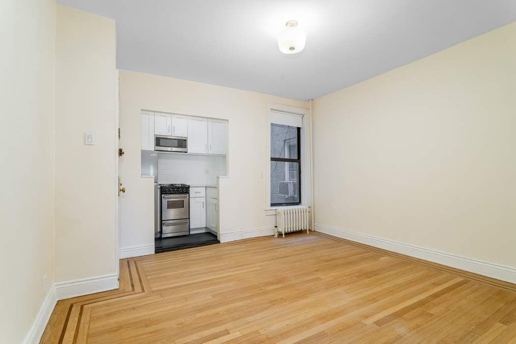 a view of empty room with a fireplace and window