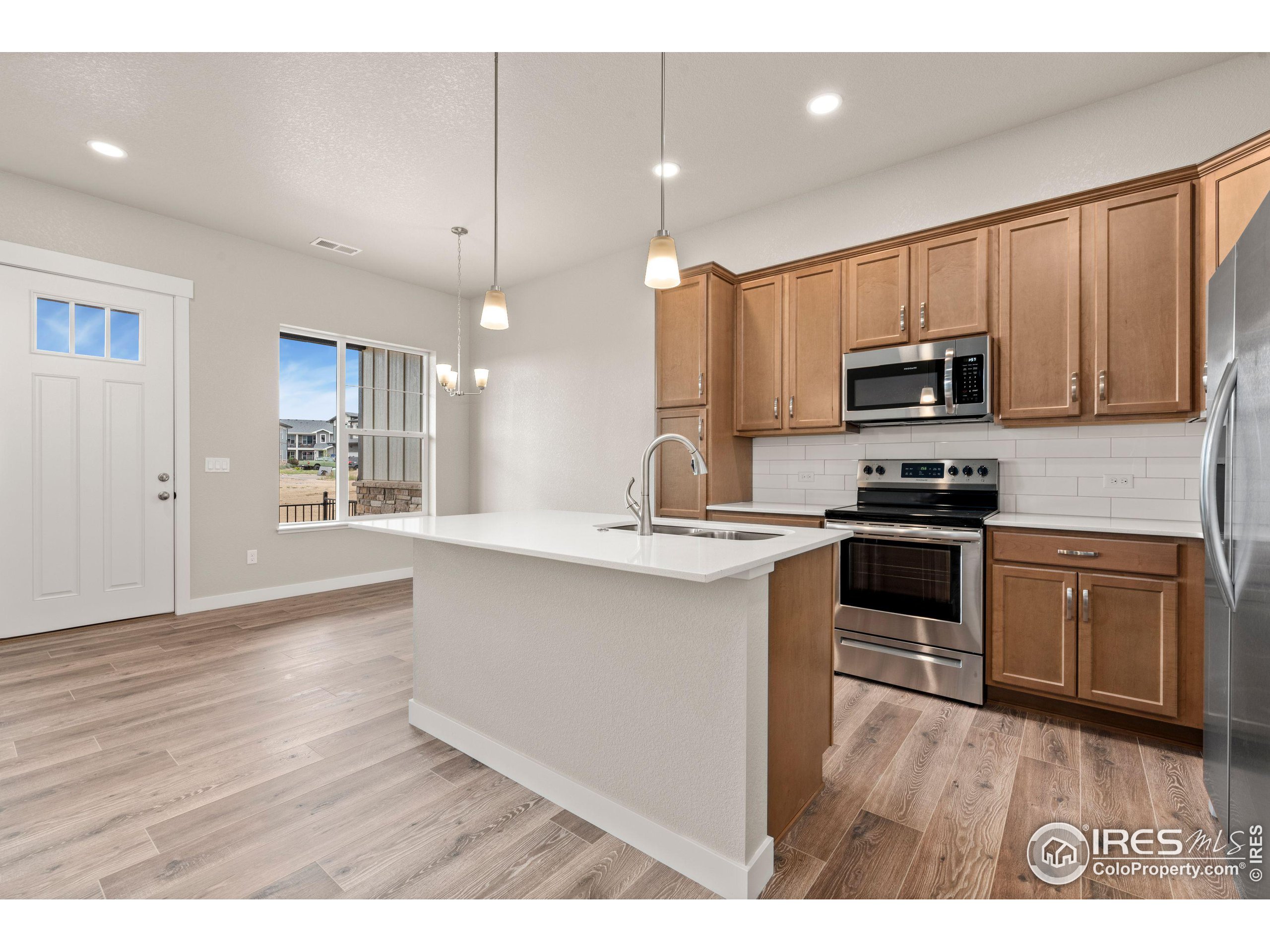 a kitchen with kitchen island granite countertop a sink cabinets and stainless steel appliances