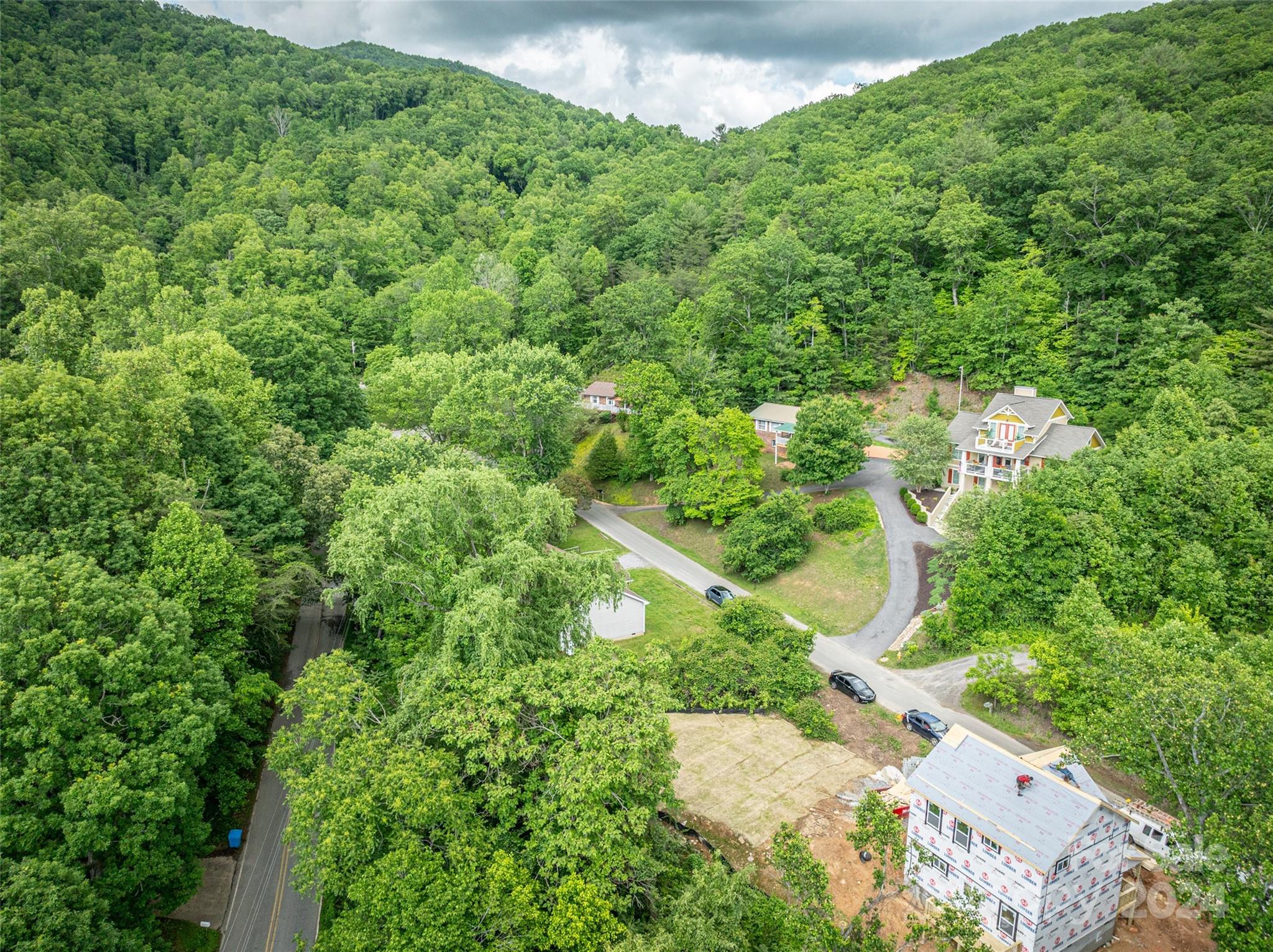 an aerial view of residential house with outdoor space and trees all around