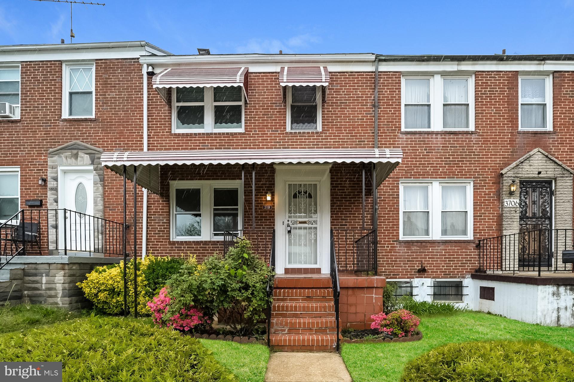 front view of a brick house with a yard