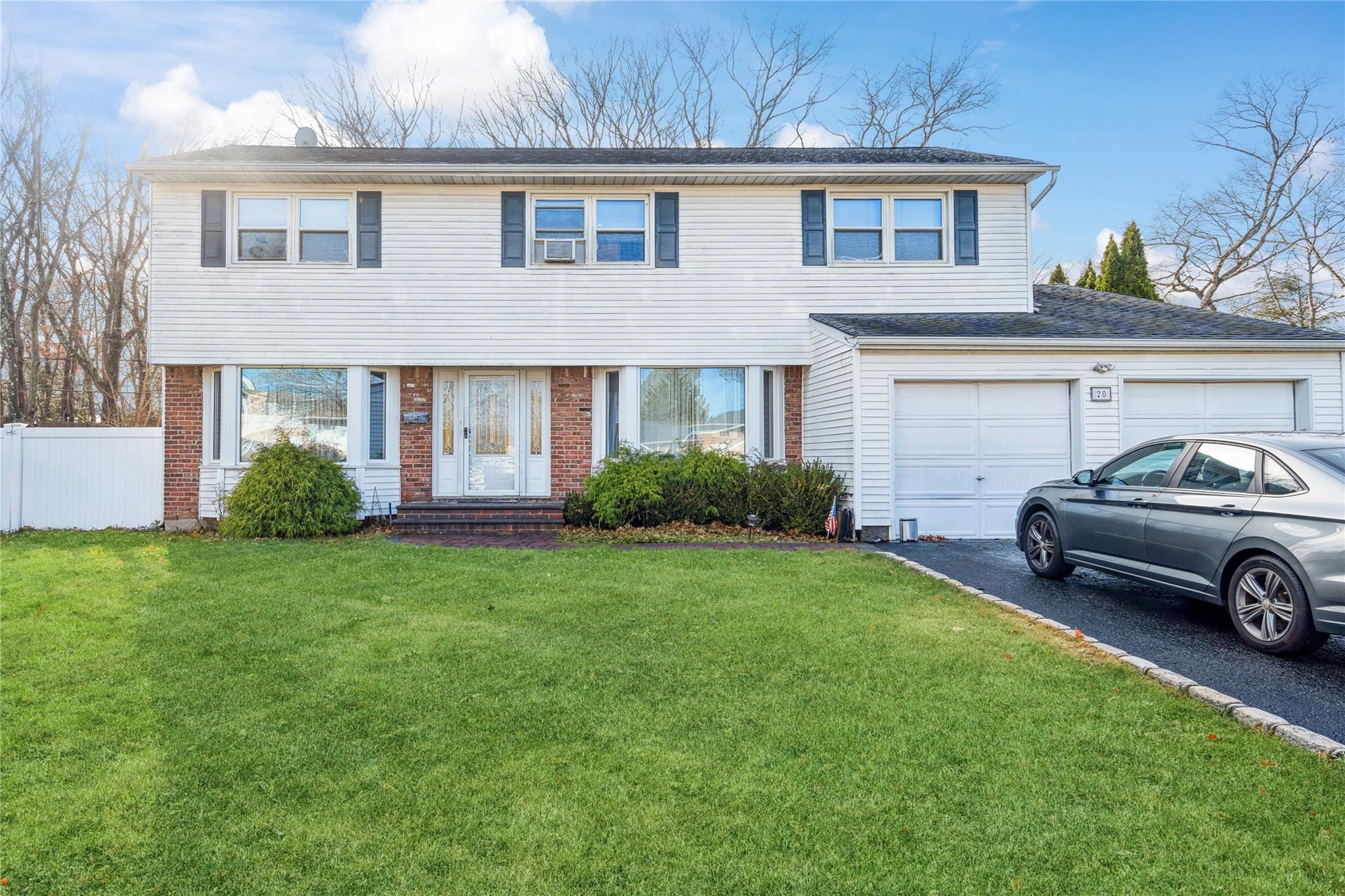 View of front property featuring a front yard and a 2 car garage