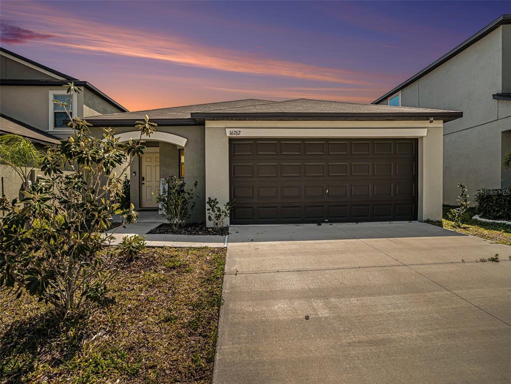 a front view of a house with a yard and garage