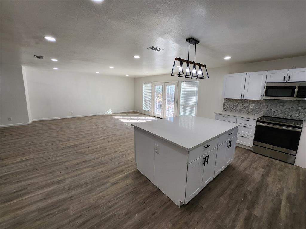 a kitchen with granite countertop a sink and a stove